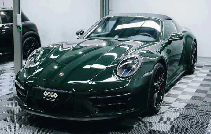 a green sports car parked in a garage